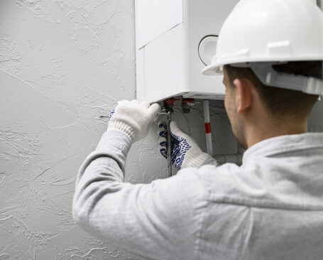 worker-repairing-water-heater-in-home